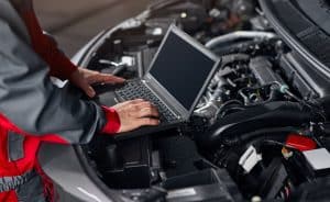 Crop mechanic conducting car diagnostics in workshop