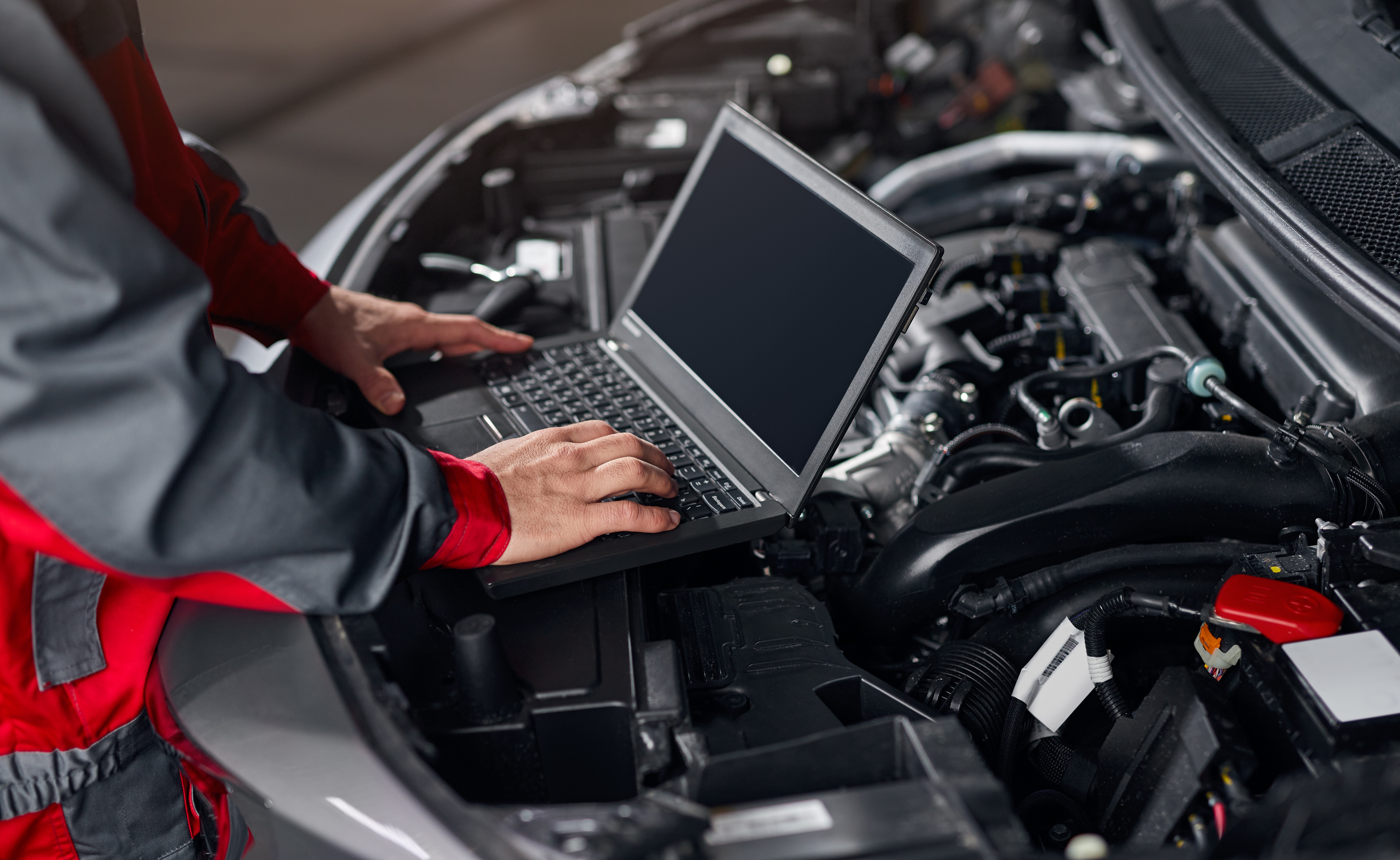 Crop mechanic conducting car diagnostics in workshop